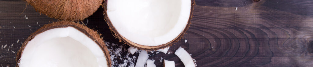 Coconut halves with shell on a dark background. Top view with copyspace
